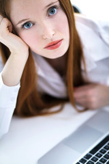 Young business woman using a laptop computer on the table isolat