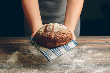 Cook holds a handmade black bread.