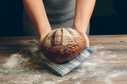 Cook holds a handmade black bread.