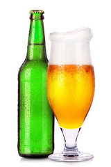 Glass and bottle of beer with drops isolated on white
