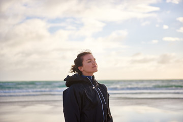 Woman enjoying fresh ocean air on a winter beach