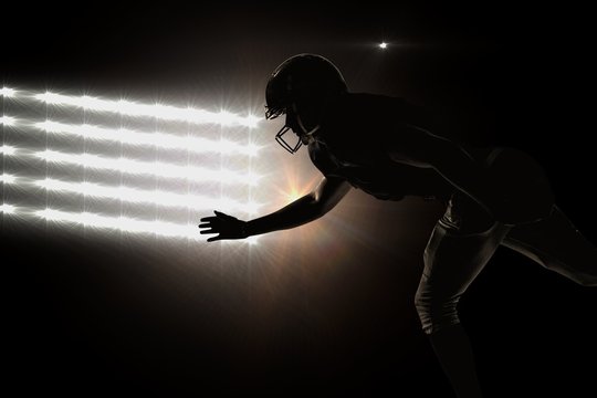 Composite image of silhouette american football player jumping
