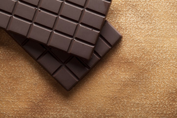 Dark chocolate bar on brown handmade paper background