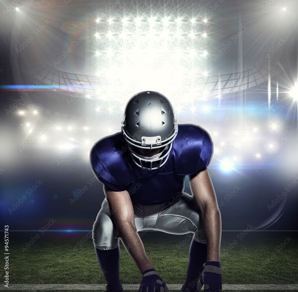 Poster American football player holding ball while crouching