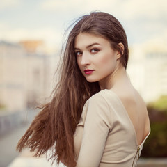 Young beautiful woman in a beige dress