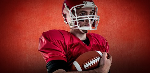 Composite image of american football player holding ball