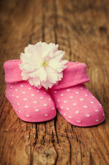 Baby girl shoes for a baby shower with pink flower on vintage wo
