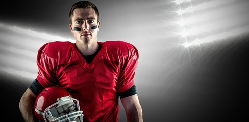 Composite image of american football player holding ball