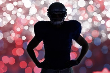 Composite image of silhouette american football player standing