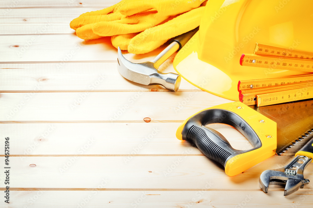 Wall mural hard hat and various tools on wooden background