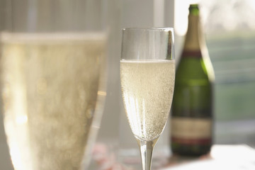 Champagne glasses and champagne bottle out of focus behind.