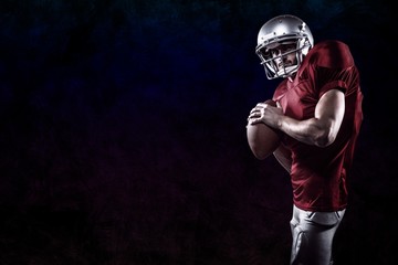 Composite image of american football player holding ball