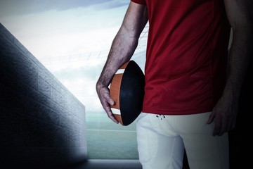 Composite image of midsection of a player holding rugby ball