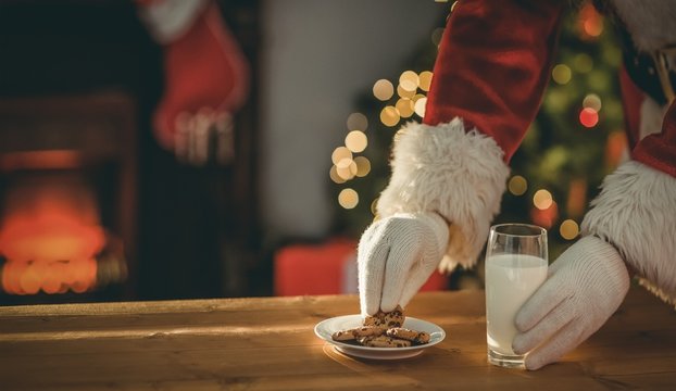 Santa claus picking cookie and glass of milk