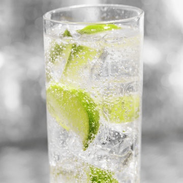 Glass of soda with ice and sliced fresh lime