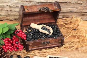 Dried black beans on wood background.