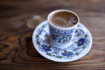 Traditional Turkish coffee served in cup on wooden table