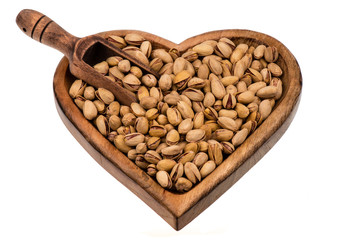 Salted pistachios nuts on the wooden plate isolated.