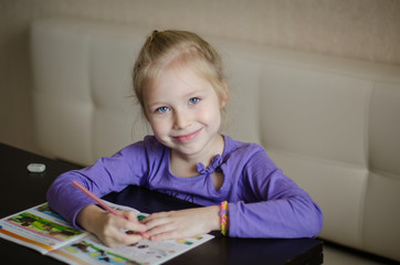 cute happy little girl writing something in her notebook