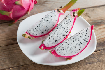 Slice of dragon fruit on white plate. Selective focus.