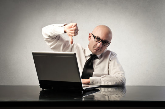 Disappointed businessman sitting in front of a laptop