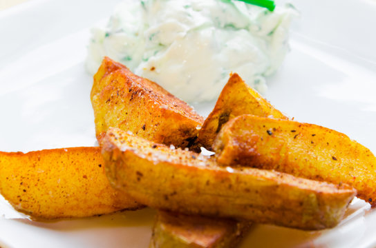 Front view on fried potatoes with creamy dip