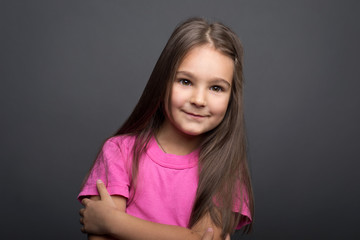 Fototapeta premium Portrait of a little girl on a gray background