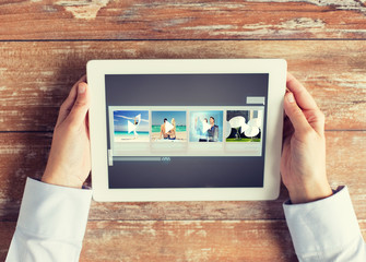 close up of hands with video gallery on tablet pc