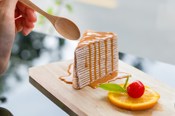 Thai tea crape cake , Using a spoon cutting the cake