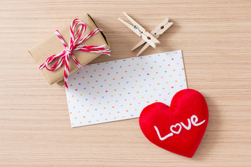 Envelope with red heart, peg, gift box valentine day on wooden table background