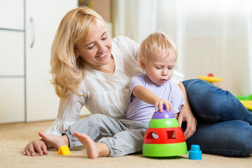 Obraz premium mother and her child playing with colorful logical toy