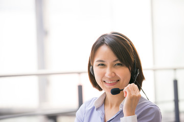 Asian Business woman talking using her headset in the office