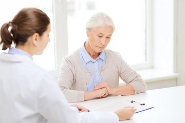 doctor with clipboard and senior woman at hospital