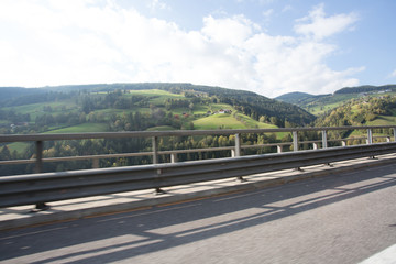 Road, green meadows, blue sky