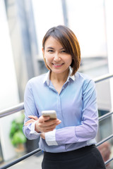 Asian businesswoman talking on a mobile phone at the office