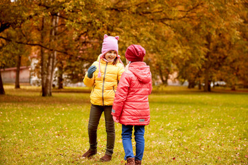 two happy little girls in autumn park