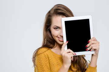 Woman covering half face with tablet computer