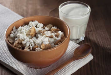 Cottage cheese with cereals in clay and glass salad bowl with yo