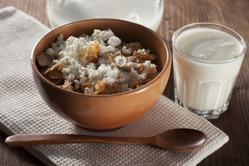 Cottage cheese with cereals in clay and glass salad bowl with yo