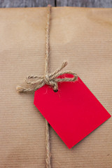 gift in kraft paper with red card  on a wooden table
