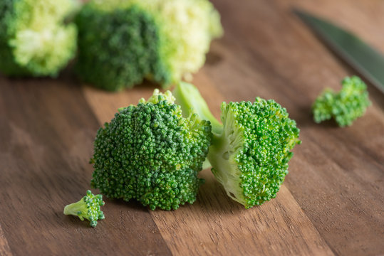 Sliced of broccoli on wood background.