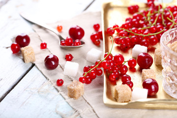 Fresh red currants with sugar on table close up