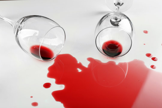 Spilled wine from glasses on white background