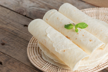 Homemade whole wheat flour tortillas on wooden table.
