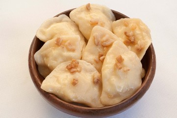 Dumplings with bacon in a clay bowl 