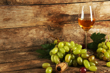 Grape with wine glass on wooden background