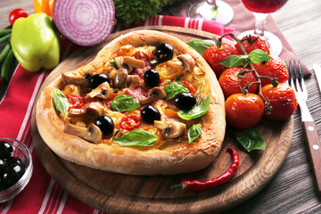 Heart shaped pizza served on wooden table, closeup