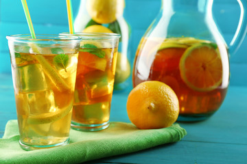 Fototapeta na wymiar Iced tea with lemon on color wooden background