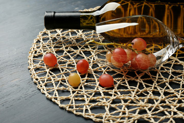 Fototapeta na wymiar Bottle of wine and grape on wooden table