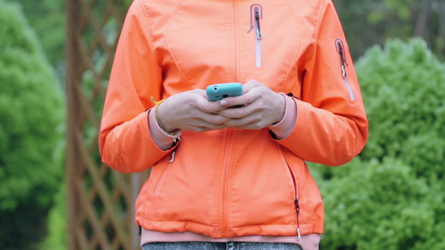 Girl typing on smartphone and putting it into pocket
